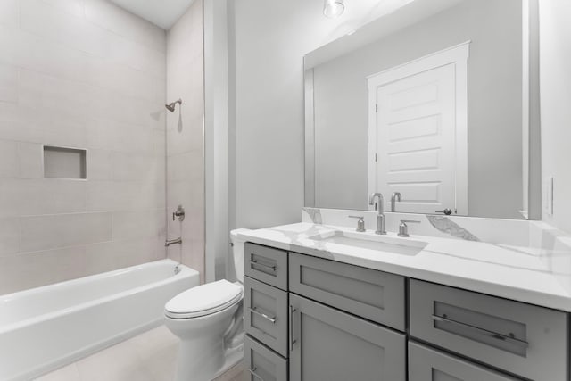 full bathroom with tile patterned flooring, vanity, tiled shower / bath combo, and toilet