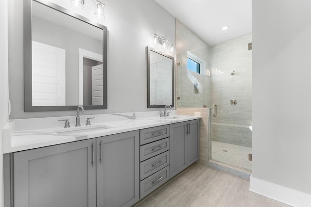 bathroom with hardwood / wood-style flooring, vanity, and walk in shower