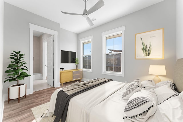 bedroom featuring ceiling fan, light wood-type flooring, and ensuite bathroom