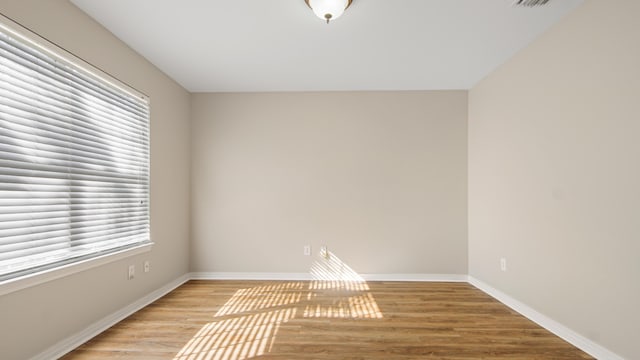 unfurnished room with light hardwood / wood-style floors and a wealth of natural light