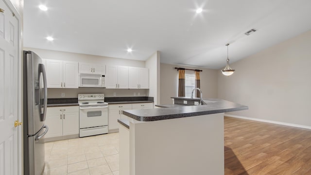 kitchen with pendant lighting, white cabinets, white appliances, and a kitchen island with sink