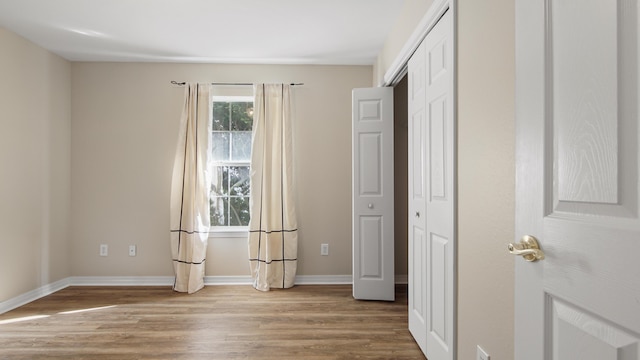 unfurnished bedroom featuring light hardwood / wood-style floors and a closet