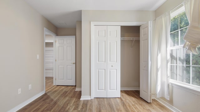 unfurnished bedroom featuring a closet and light hardwood / wood-style flooring