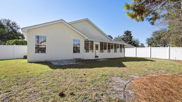 back of house with a lawn and a sunroom