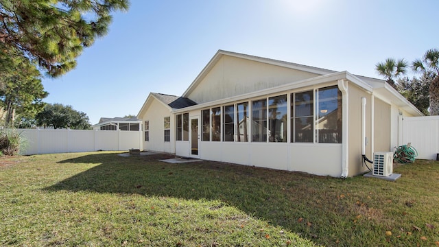 back of house featuring a lawn, cooling unit, and a sunroom