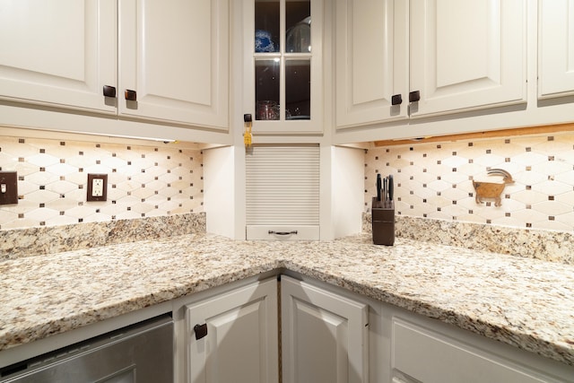 details featuring light stone counters, white cabinetry, and tasteful backsplash