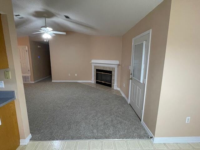 unfurnished living room featuring ceiling fan, vaulted ceiling, a fireplace, and light carpet