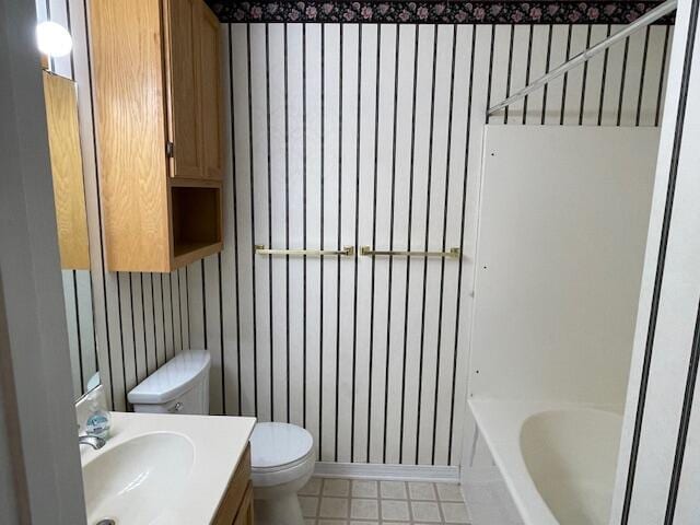 bathroom featuring toilet, vanity, and a washtub