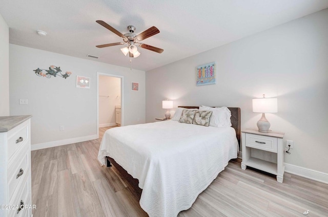 bedroom with ceiling fan, light wood-type flooring, and ensuite bathroom