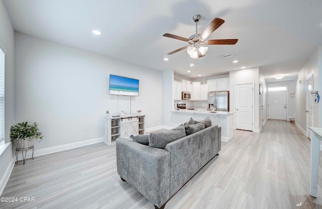 living room with light wood-type flooring and ceiling fan