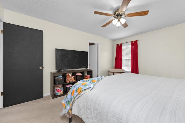 carpeted bedroom featuring a textured ceiling and ceiling fan