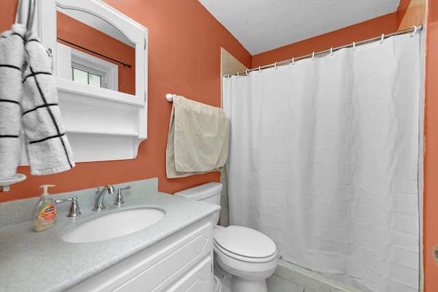 bathroom with vanity, toilet, and a textured ceiling