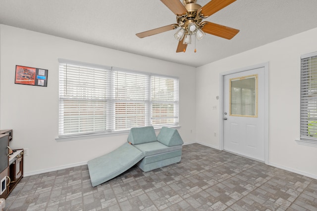 sitting room featuring ceiling fan and a textured ceiling