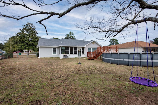 rear view of property with a yard and a sunroom