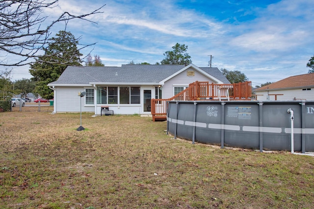 back of property with a lawn and a sunroom