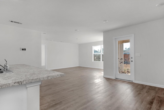 unfurnished living room with hardwood / wood-style floors and sink