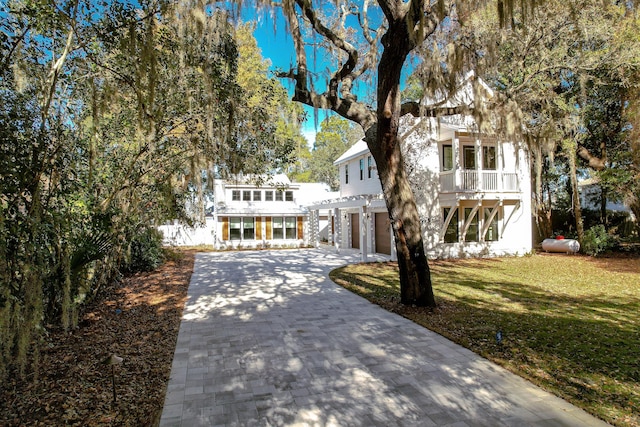 view of front facade featuring a balcony and a front yard