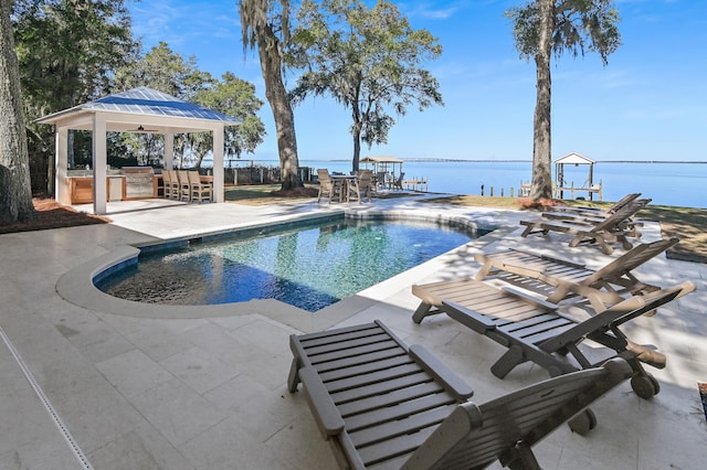 view of pool featuring a patio, exterior bar, exterior kitchen, a gazebo, and a water view