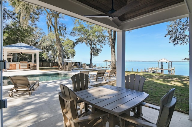 view of patio with ceiling fan, a gazebo, and a water view