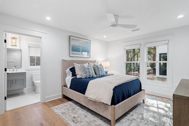 bedroom featuring ceiling fan, connected bathroom, light hardwood / wood-style flooring, and sink