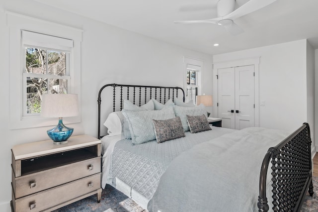 bedroom with dark hardwood / wood-style flooring, a closet, and ceiling fan