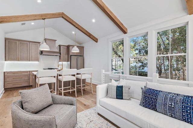 living room featuring vaulted ceiling with beams and light hardwood / wood-style floors