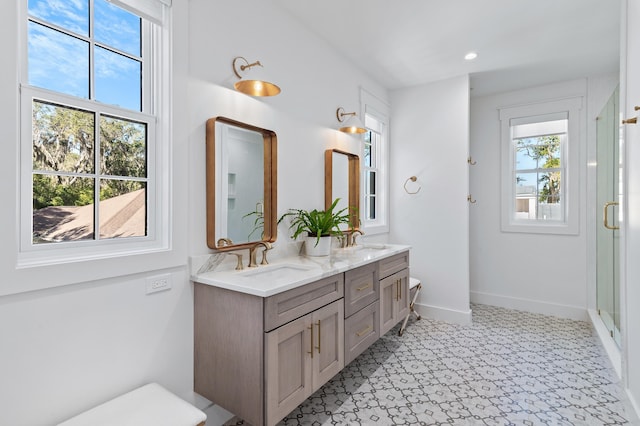 bathroom featuring a shower with door and vanity