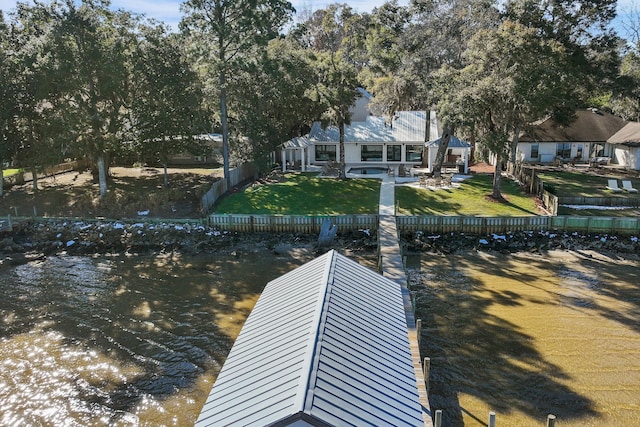 view of dock featuring a patio, a water view, and a lawn