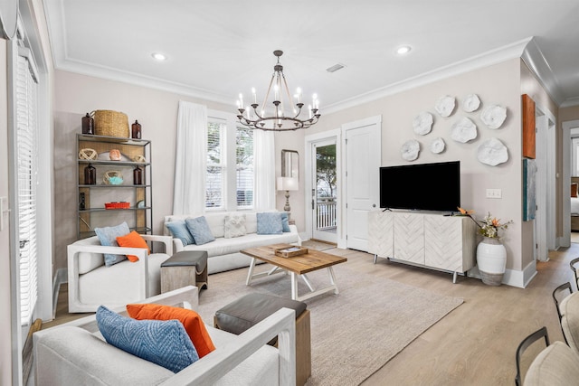 living room featuring light hardwood / wood-style floors, crown molding, and a notable chandelier