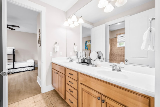 bathroom featuring tile patterned flooring, vanity, and ceiling fan with notable chandelier