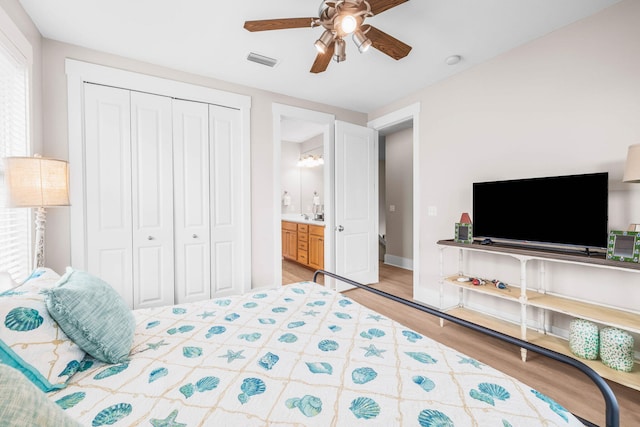 bedroom featuring ceiling fan, wood-type flooring, ensuite bathroom, and a closet