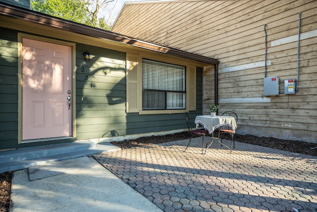 view of exterior entry with a patio