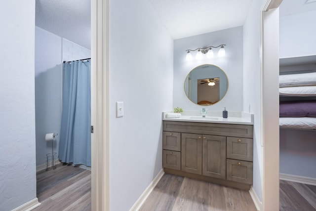 bathroom with vanity, hardwood / wood-style flooring, a textured ceiling, and a shower with curtain