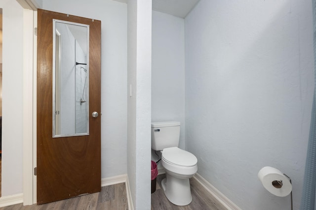 bathroom with toilet and hardwood / wood-style floors