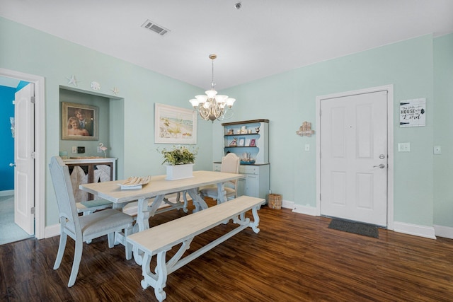 dining space featuring dark hardwood / wood-style floors and a notable chandelier