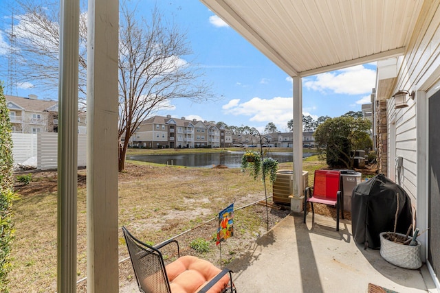 view of patio / terrace featuring a water view, cooling unit, and a grill