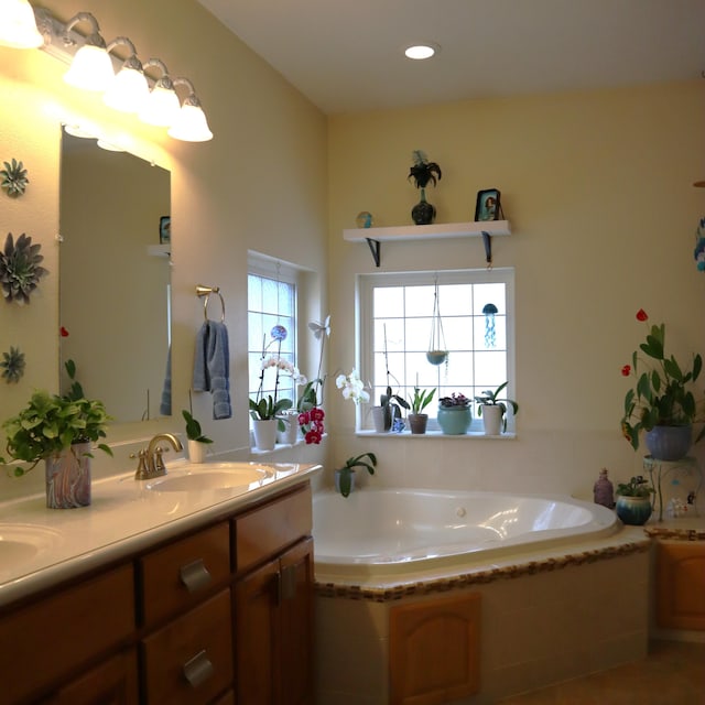 bathroom with vanity and a relaxing tiled tub