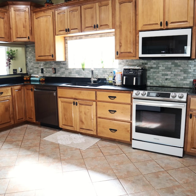 kitchen with light tile patterned flooring, white appliances, sink, and tasteful backsplash