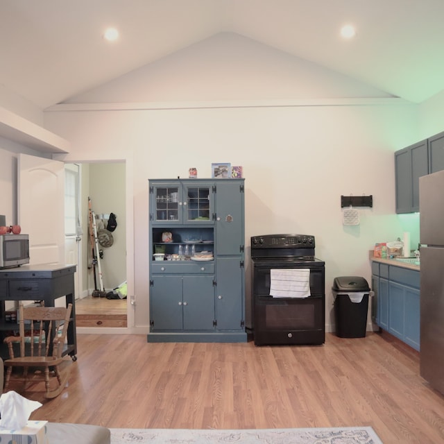 kitchen with appliances with stainless steel finishes, light wood-type flooring, blue cabinets, and vaulted ceiling