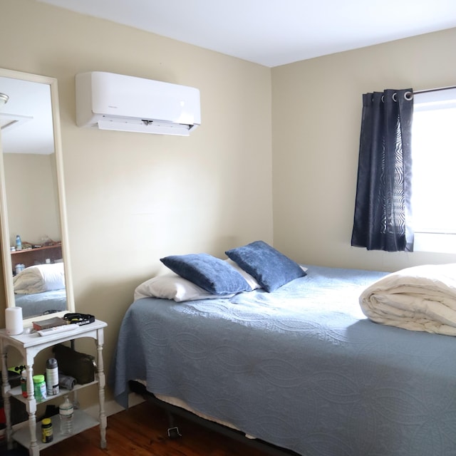 bedroom featuring dark hardwood / wood-style flooring and an AC wall unit