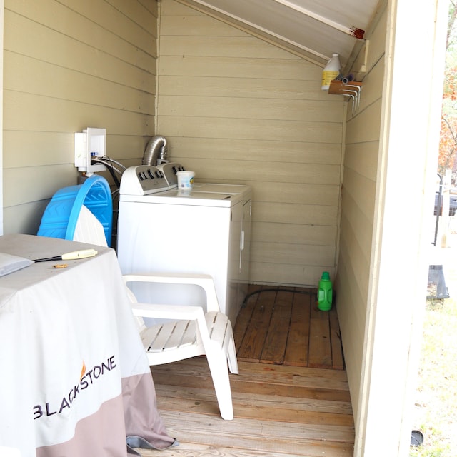 laundry room featuring washer and dryer and wooden walls