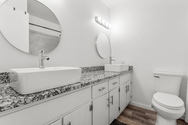 bathroom with hardwood / wood-style floors, vanity, and toilet