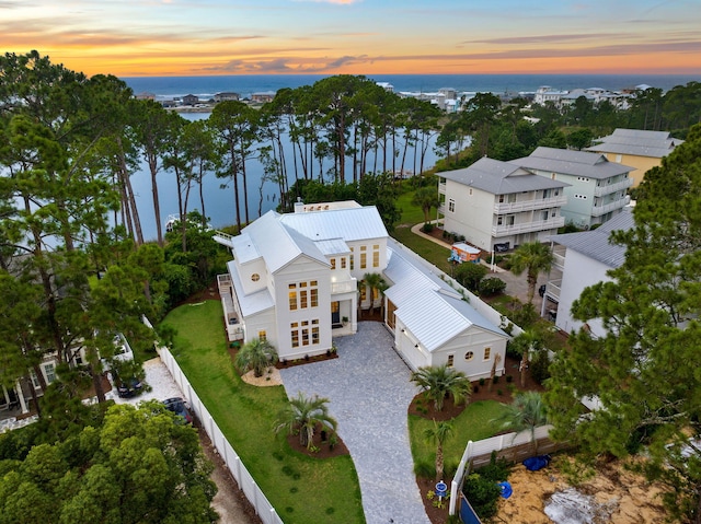 aerial view at dusk featuring a water view