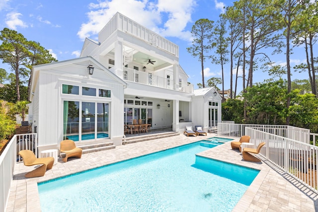 rear view of house with ceiling fan, a patio area, a fenced in pool, and a balcony