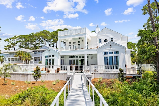 rear view of house featuring a balcony and a pool