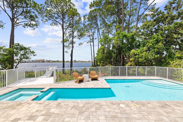 view of pool with an in ground hot tub, a patio, and a water view