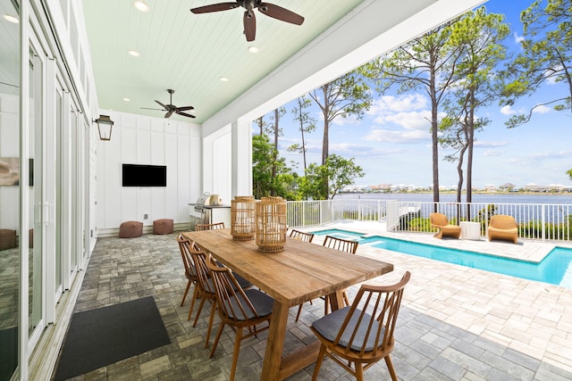 view of patio with ceiling fan and a swimming pool with hot tub