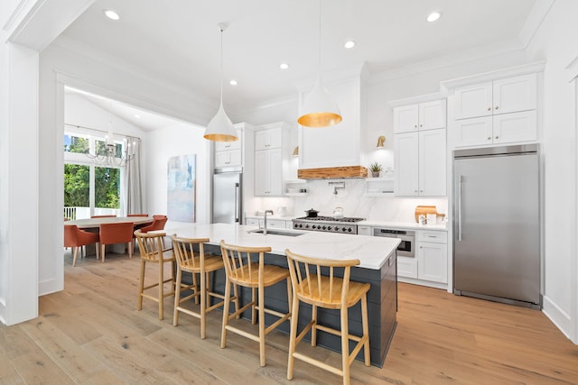 kitchen with white cabinetry, a kitchen island with sink, appliances with stainless steel finishes, and tasteful backsplash