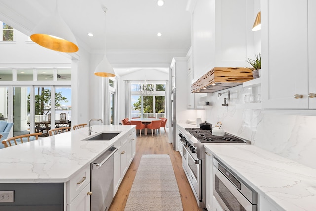 kitchen with tasteful backsplash, appliances with stainless steel finishes, decorative light fixtures, white cabinets, and custom exhaust hood