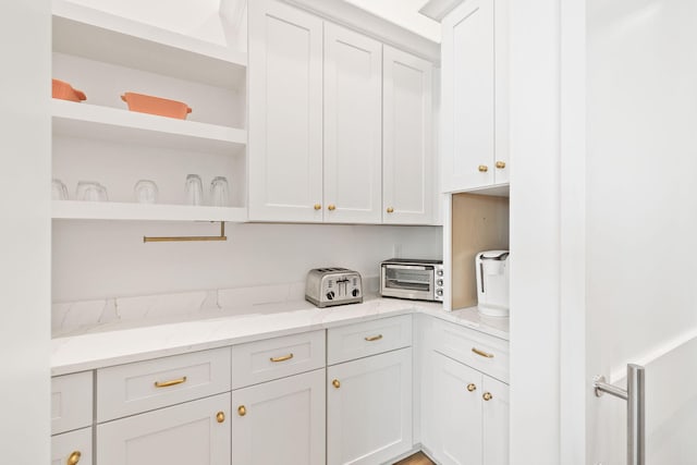 kitchen with light stone counters and white cabinetry